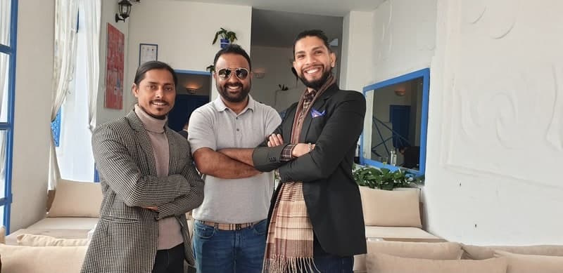Samir with two collaborators in a bright café